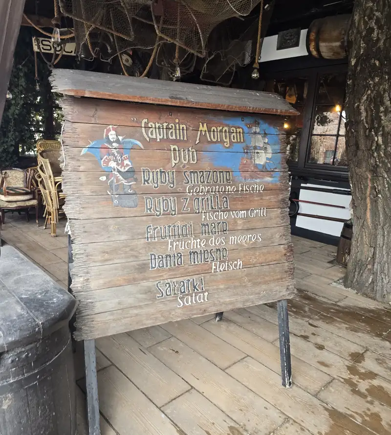 Menu z malowanego szyldu przed pubem