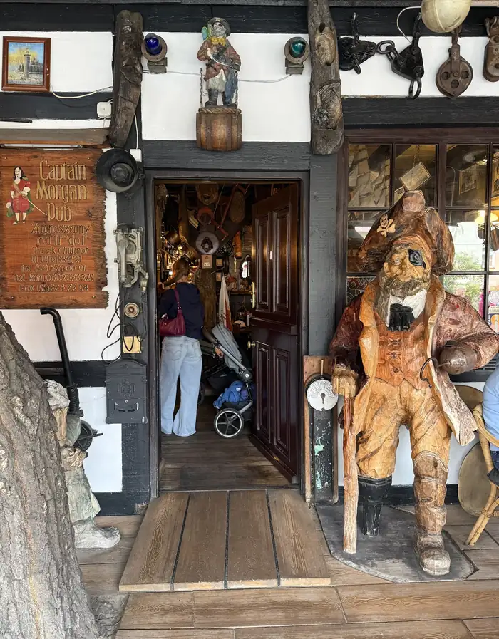 Wejście do pubu z rzeźbą pirata i szyldem Captain Morgan Pub